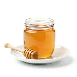 Jar of honey with a dipper