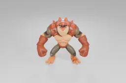 Muscular, cartoonish action figure with orange skin and lizard-like features