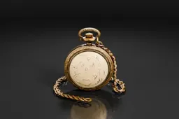 Gold pocket watch with a chain attached to it