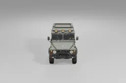 Rugged green military-style off-road vehicle stands on thick tires, equipped