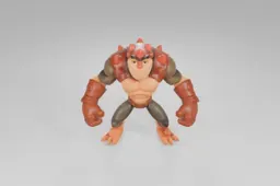 Muscular, cartoonish action figure with orange skin and lizard-like features